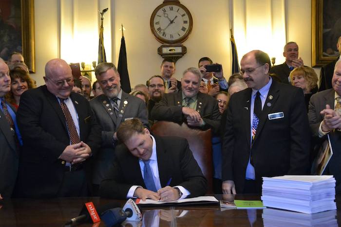 Governor Chris Sununu signs New Hampshire’s constitutional-carry law, February 22, 2017, surrounded by supporters.